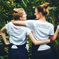 two girls hugging in do good tshirts outdoors